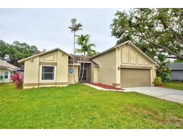 Charming single-story home featuring a well-maintained lawn, two-car garage, and mature landscaping at 1955 Cobblestone Way, Clearwater, FL 33760