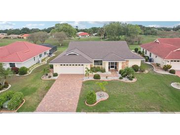 Beautiful single-Gathering home featuring lush landscaping and a brick-paved driveway at 1972 Wolf Laurel Dr, Sun City Center, FL 33573