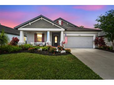 Charming single-Gathering home boasting a well-manicured lawn, vibrant flowers, and neutral gray tones at 19836 Hidden Glen Dr, Land O Lakes, FL 34638