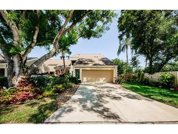Charming home featuring lush landscaping, a driveway, and an attached two-car garage at 3174 Eagles Landing W Cir # 58, Clearwater, FL 33761