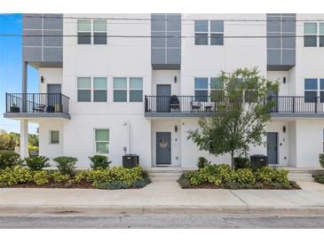 Modern townhome exterior with white facade, gray accents, balconies, and landscaped entrance at 4120 W North A St # 2, Tampa, FL 33609