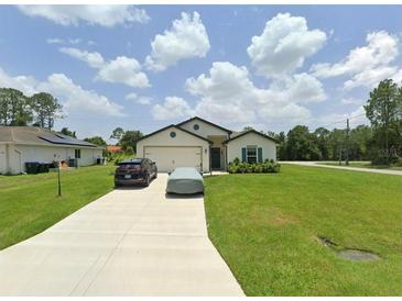 Charming single-story home with a well-manicured lawn and paved driveway at 5407 Kedgewick Ln, North Port, FL 34288