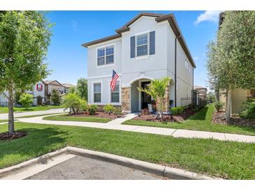 Charming two-story home with a well-manicured lawn and a welcoming front porch at 5717 Village Center Dr, Lithia, FL 33547