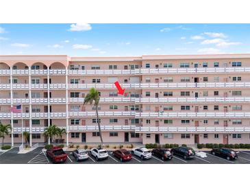 Multi-story condo building with several units, palm trees, and parking at 6025 Shore S Blvd # 409, Gulfport, FL 33707
