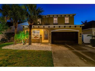Two-story home featuring a front yard with palm trees and white rock landscaping, plus a two-car garage at 7705 S Sparkman St, Tampa, FL 33616