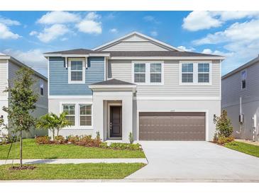 Charming two-story home featuring a well-manicured lawn and a two-car garage at 9955 Surrey Rose Dr, San Antonio, FL 33576