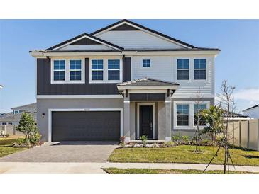 Two-story home featuring a two-car garage, a manicured lawn, and a well-maintained exterior at 9961 Surrey Rose Dr, San Antonio, FL 33576