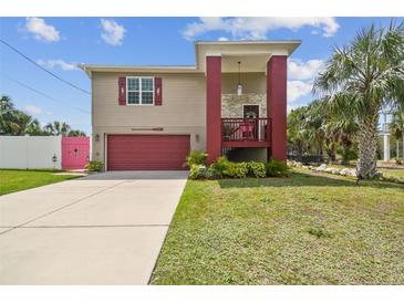 Charming two-story home with a red-colored garage door and a cozy front porch at 3227 Rose Arbor Dr, Hernando Beach, FL 34607