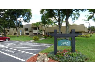 Well-maintained condo building with lush landscaping and a clearly marked sign at 36750 Us 19 N # 07208, Palm Harbor, FL 34684