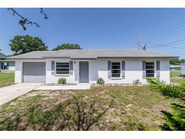 Charming single-story home with a freshly painted white exterior and well-manicured front yard at 5341 Tangerine Dr, Zephyrhills, FL 33542