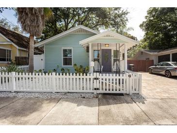 Charming home with a white picket fence, front porch, and manicured landscaping at 945 8Th N St, St Petersburg, FL 33712
