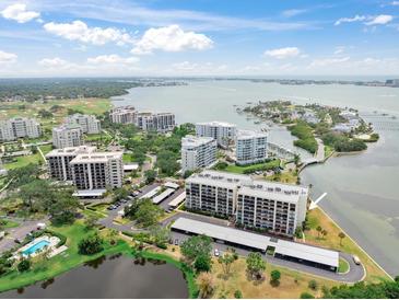 Stunning aerial view of condo community, showcasing beautiful landscaping, waterfront access, and nearby golf course at 100 Oakmont Ln # 310, Belleair, FL 33756