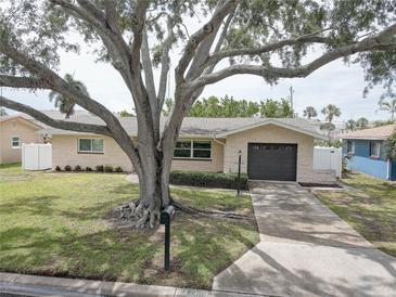 Charming single-story home with a well-manicured lawn and mature tree at 11188 64Th Ter, Seminole, FL 33772