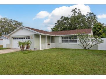Charming single-story home with a well-maintained lawn, attached garage, and inviting front porch at 11991 104Th Ave, Seminole, FL 33778