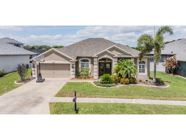 Charming single-story home with a well-manicured lawn and a two-car garage at 5049 Rushbrook Rd, Land O Lakes, FL 34638