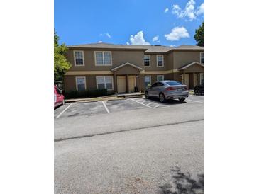 Two-story townhome featuring neutral stucco, ample parking, and close proximity to community amenities at 5915 Brickleberry Ln # 103, Zephyrhills, FL 33541