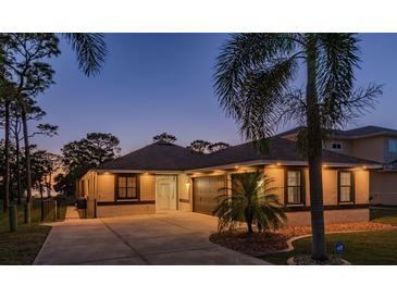 Beautiful home exterior with lush palm trees and a well-manicured lawn at dusk at 632 S Florida Ave, Tarpon Springs, FL 34689