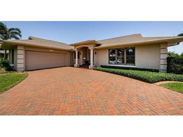 Charming single-story home with a brick driveway, manicured landscaping, and a two-car garage at 671 Tallahassee Ne Dr, St Petersburg, FL 33702