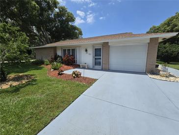 Charming single-story home featuring a well-manicured lawn, colorful landscaping and an attached one-car garage at 700 Bowsprit Pl, Palm Harbor, FL 34685
