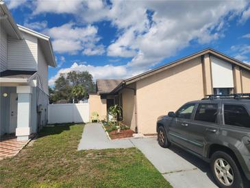 Cozy single-story home featuring a tidy front yard, a paved walkway, and a parked car along the side at 10539 Parkcrest Dr, Tampa, FL 33624