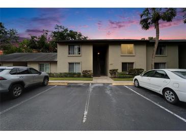 Condominium building exterior with parking lot and well-maintained landscaping at dusk at 4215 E Bay Dr # 1005D, Clearwater, FL 33764