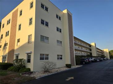 Well-maintained exterior of a condominium complex with ample parking and manicured landscaping at 5705 80Th N St # 303, St Petersburg, FL 33709