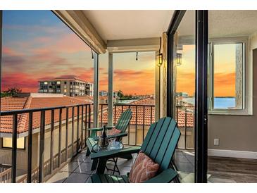 Relaxing balcony view with comfortable chairs and a table setting, perfect for enjoying the sunset at 6158 Palma Del Mar S Blvd # 306, St Petersburg, FL 33715