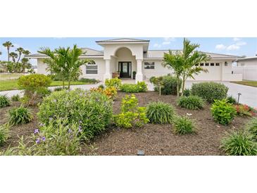 Charming single-story home featuring lush landscaping with tropical plants and a welcoming front entrance at 7060 S Shore S Dr, South Pasadena, FL 33707