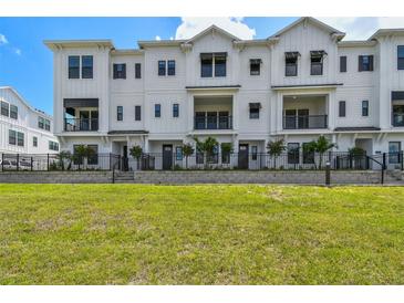 Beautiful exterior of a modern white townhome with a well-maintained green lawn at 7240 Sutton Ln, Sarasota, FL 34240