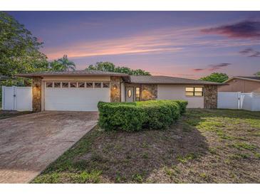 Charming single-story home boasts stone accents, a two-car garage, and a well-manicured front yard at 8744 Andros Ln, Port Richey, FL 34668