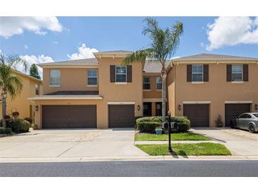 Inviting townhome with a two-car garage, manicured lawn, and a charming palm tree in a well maintained community at 9520 Trumpet Vine Loop, Trinity, FL 34655