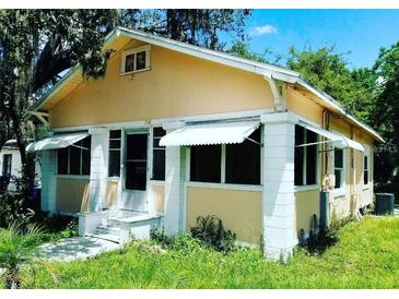 Quaint single-story home with awnings and a covered porch, needs yardwork and minor repairs at 1118 E Linebaugh Ave, Tampa, FL 33612