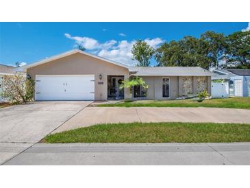 Charming single-story home with a well-manicured lawn, two-car garage, and welcoming front entryway at 13263 86Th Ave, Seminole, FL 33776