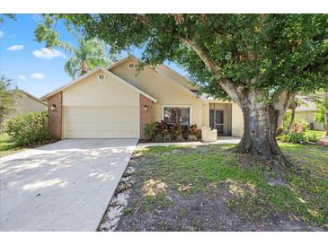 Charming single-story home featuring a well-maintained front yard, mature trees, and a two-car garage at 1914 Elk Spring Dr, Brandon, FL 33511