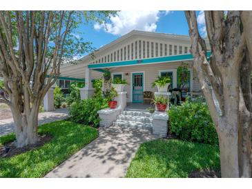 Charming bungalow featuring well-maintained landscaping and a covered front porch with a pop of turquoise accents at 204 E North St, Tampa, FL 33604