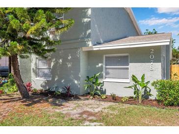 Charming home exterior with a beautifully landscaped front yard and healthy, green plants and trees at 2078 Madrid N Ct, Clearwater, FL 33763