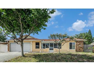 Charming single-story home with a well-manicured lawn, attached garage, and inviting curb appeal at 2632 Tung Dr, Holiday, FL 34691