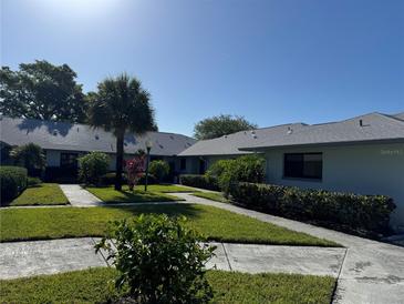 Well-maintained condo community with mature landscaping, sidewalks, and lush green lawns at 2753 Countryside Blvd # 107, Clearwater, FL 33761