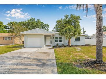 Charming single-story home featuring a well-manicured lawn, attached garage, and inviting front entrance at 2858 State Road 590, Clearwater, FL 33759