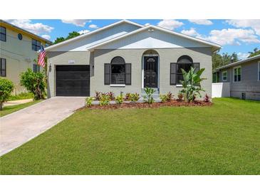 Charming single-story home featuring a well-maintained front yard and classic architectural details at 7208 S Juanita St, Tampa, FL 33616
