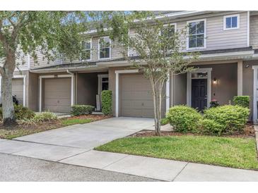 Inviting townhome with a well-manicured lawn, attached garage, and neutral exterior paint at 8007 Bally Money Rd, Tampa, FL 33610