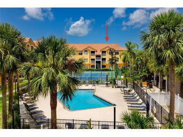 Resort-style condo complex featuring a sparkling pool, tennis court, palm trees and tropical landscaping at 10764 70Th Ave # 5302, Seminole, FL 33772