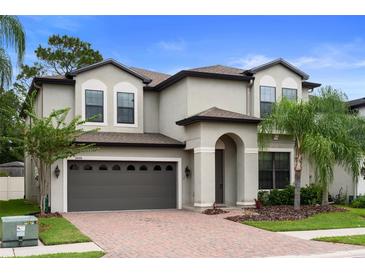 Stunning two-story home boasts a brick driveway, manicured lawn, and a two-car garage at 11006 Tahiti Isle Ln, Tampa, FL 33647