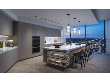 Modern kitchen features a large island with seating, marble countertops, and floor-to-ceiling windows with city views at 1101 E Jackson St # 2302, Tampa, FL 33602