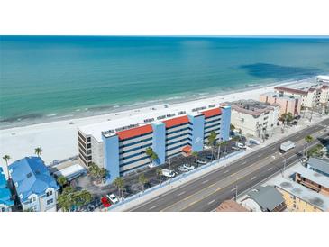 Beautiful aerial view of the condo community nestled along a pristine white sand beach with clear turquoise ocean waters at 13720 Gulf Blvd # 302, Madeira Beach, FL 33708