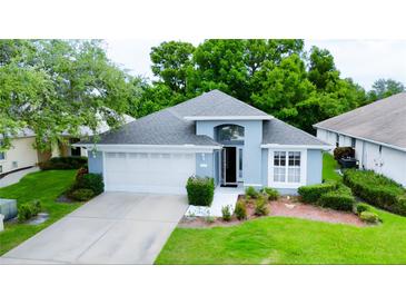 Charming single-story home features a well-manicured lawn, attached two-car garage, and freshly painted exterior at 14116 Whitecap Ave, Hudson, FL 34667