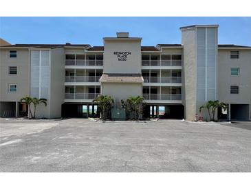 Three story condo building offering covered parking, balconies, and convenient beach access at 16330 Gulf Blvd # 201, Redington Beach, FL 33708