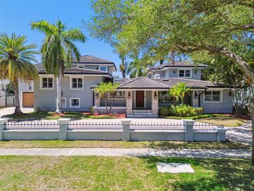 Elegant two-story home featuring a tile roof, manicured landscaping, and a secure wrought iron fence at 405 S Shore Crest Dr, Tampa, FL 33609