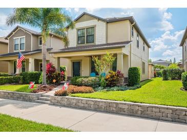 Charming two-story home featuring a welcoming front porch and beautifully landscaped front yard at 4264 Bexley Village Dr, Land O Lakes, FL 34638