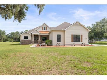 Charming single-story home featuring a lush lawn, decorative accents, and a welcoming facade at 5319 W Trapnell Rd, Dover, FL 33527